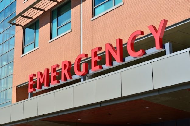 The imposing, red "EMERGENCY" sign at the entrance to a hospital