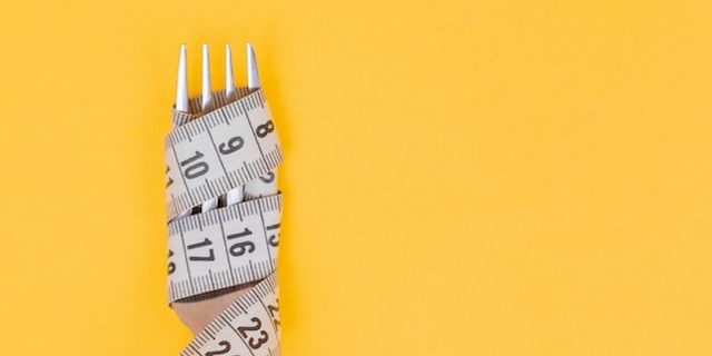 Measuring tape wrapped tight around a fork