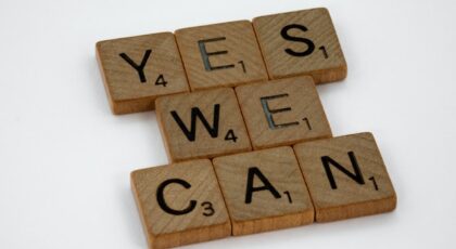 Scrabble game pieces spell out, "yes we can".