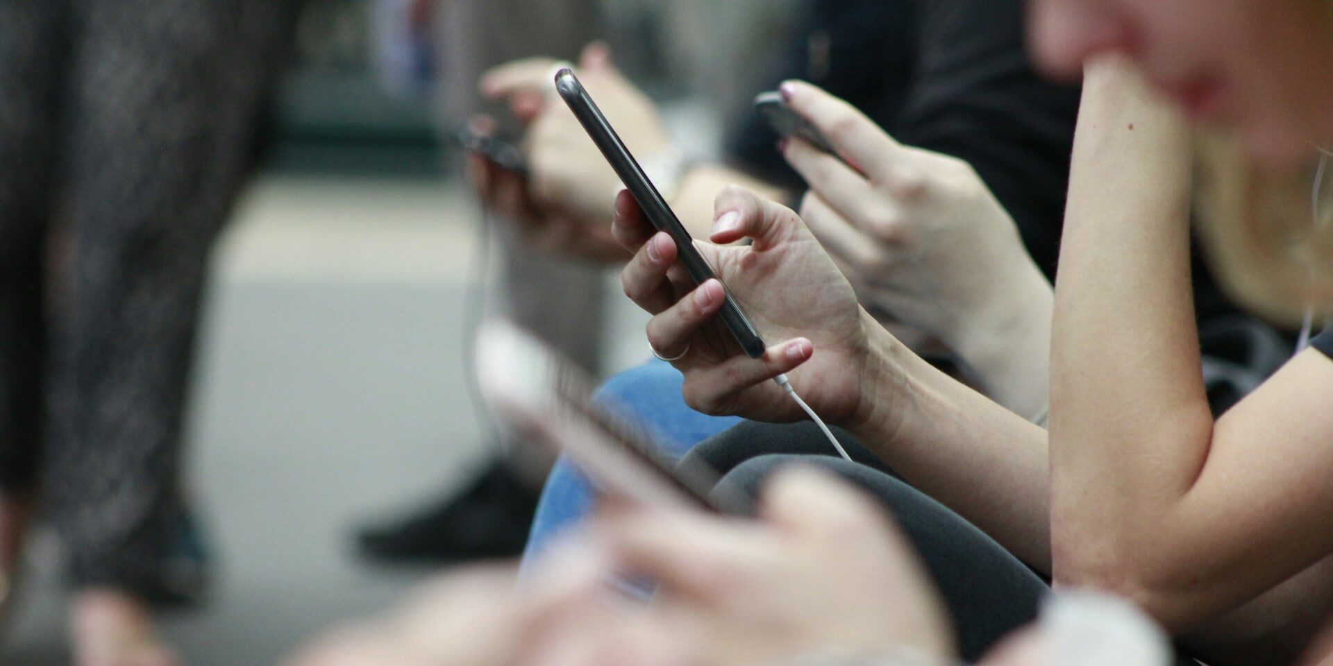 Several teens use their phones in a closeup shot of their hands.