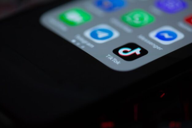 An iPhone home screen with the tiktok app in deep focus.