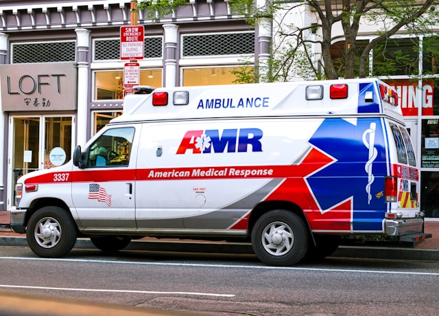 nami-santa-clara-county-trust-program An ambulance parked on the curb outside of various shops.