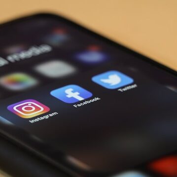 An iPhone displaying app icons for Instagram, Facebook, and twitter.