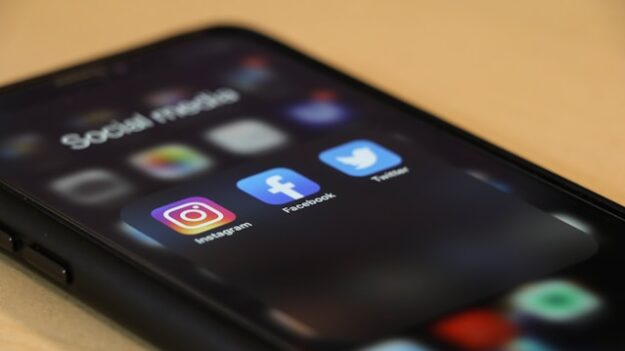 An iPhone displaying app icons for Instagram, Facebook, and twitter.
