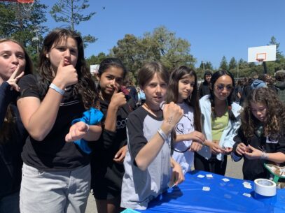A group of teens pose for a picture in front of the EDRCSV table at the Scott's Valley Middle School Wellness Fair.