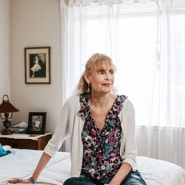 EDRC Founder Janice Bremis sits contemplatively on a bed.